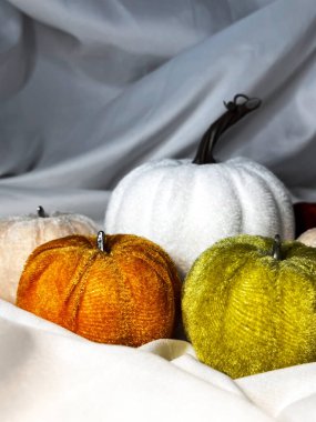 Beyaz tekstil arka planında kumaş tekstil kabakları. Üst Manzara. Cadılar Bayramı el yapımı balkabakları, dikiş..