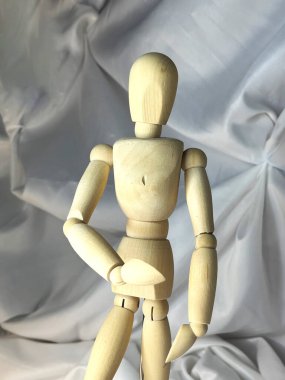 Beyaz tekstil arka planındaki sanatçılara poz vermek için ahşap model manken
