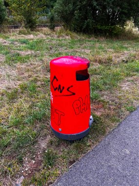 Parkta yer çekimi olan kırmızı çöp kutusu. Çöp odaklı. Çöp amblemi