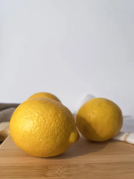 Tahtada taze limonlar ve beyaz arka planda bej bir kumaş. Atmosferik fotoğraf