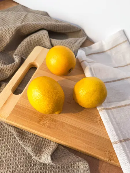 Tahtada taze limonlar ve beyaz arka planda bej bir kumaş. Atmosferik fotoğraf