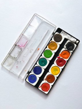 Beyaz arka planda boyalar olan plastik palet. Yuvarlak hücreli. Üst Görünüm.