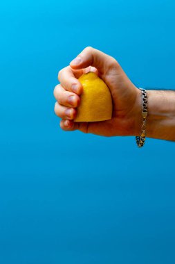 Mavi arka planda bir limonu sıkmak