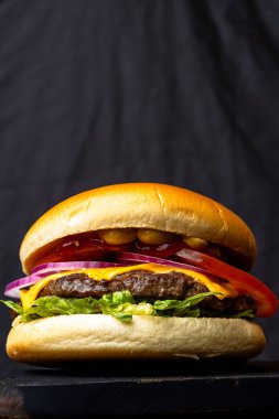 Domatesli sulu burger, marul, soğan ve köfte.