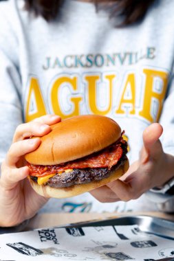 Yemekten önce ellerde iştah açıcı bir burger.