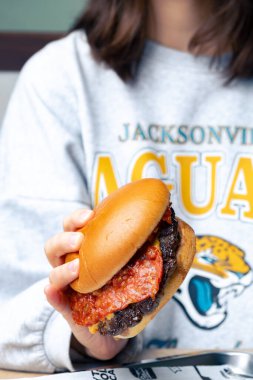 Yemekten önce ellerde iştah açıcı bir burger.