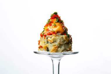 Kompozisyon - beyaz arkaplanda şarap kadehinin sapında suşi rulosu