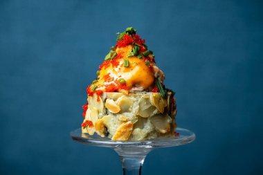 Kompozisyon - mavi arkaplanda şarap kadehinin sapında suşi rulosu