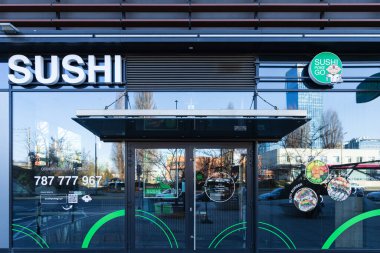 Polonya 'da bir suşi restoranının ön cephesi, yerden tavana boyalı cam pencereler.