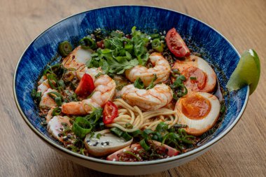 Ahşap bir masada gerçek ramen izole edilmiş üst manzara, eller, kaşık