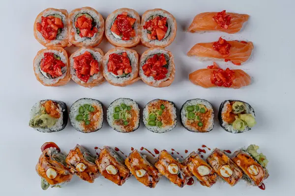 Kuşkonmaz ve çilekli suşi. Somon, kuşkonmaz, Philadelphia, California rulosu beyaz arka planda izole edilmiş.