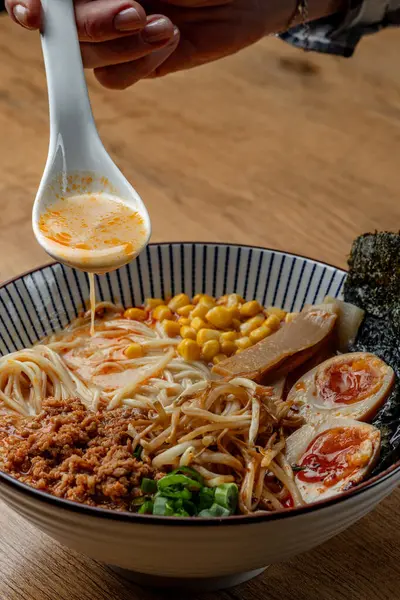 Ahşap bir masada gerçek ramen izole edilmiş üst manzara, eller, kaşık