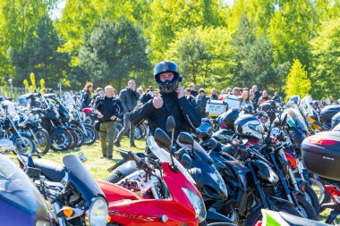 Motor fuarında kask takan dost canlısı bir motorcu.