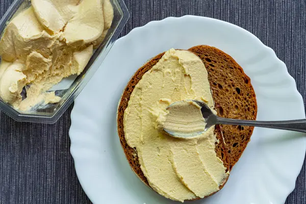 Humuslu sandviç ve beyaz tabakta ekmek.