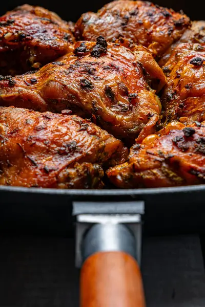 Fırınlanmış tavuk butları ve çıtır çıtır bir tava.