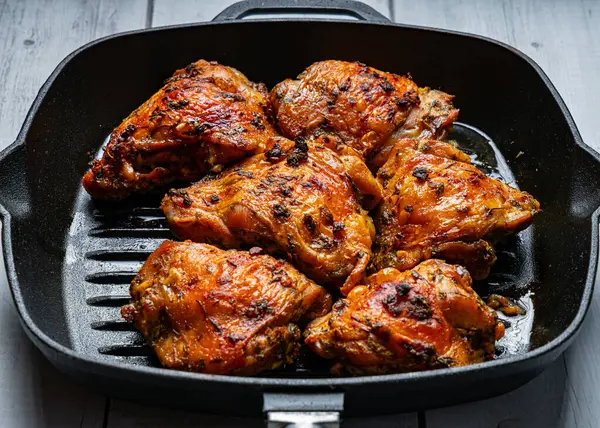 Fırınlanmış tavuk butları ve çıtır çıtır bir tava.