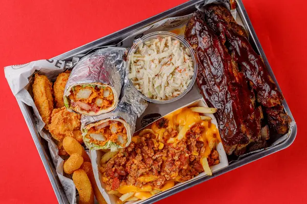 Amerikan mutfağı yakın plan kaburga, tavuk kızartması, peynir sosu, shawarma, peynir kızartması, kanat, lahana salatası.