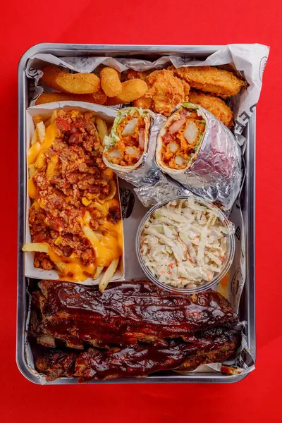 Amerikan mutfağı yakın plan kaburga, tavuk kızartması, peynir sosu, shawarma, peynir kızartması, kanat, lahana salatası.