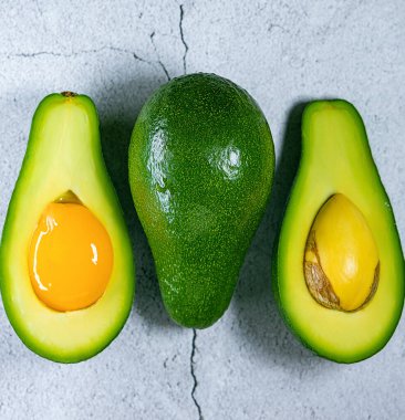 Düz zemin üzerinde taş yerine yumurta sarısı olan avokado, izole edilmiş sanat.