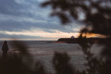 Portekiz 'de Atlantik Okyanusu kıyısında bulutlu bir gökyüzüne karşı deniz feneri.