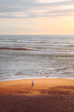 Portekiz 'in Vila Nova de Milfontes kasabasında Atlantik Okyanusu üzerinde insan ve günbatımı