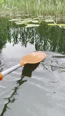 Kanodaki bir insan kürekle suyun yüzeyine zar zor dokunur..