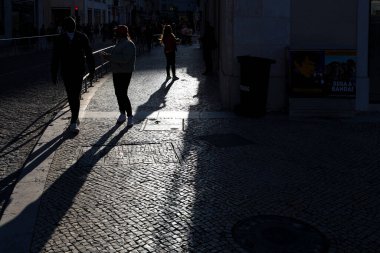 Şehirdeki insanların ve nesnelerin sert ışığı ve gölgesi