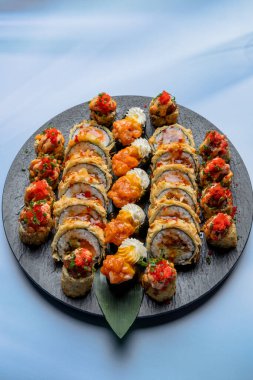 Somon, peynir, avokado, somon, yılan balığı, krema ve susamlı suşi..