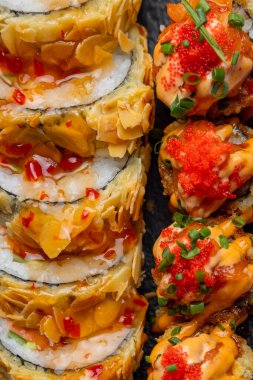 Siyah arka planda siyah bir tabakta Tempura suşi rulosu