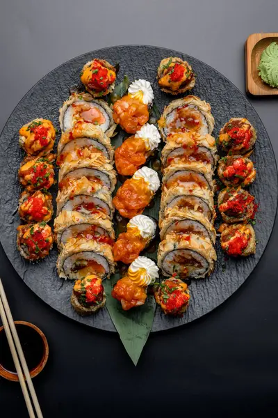Siyah arka planda siyah bir tabakta Tempura suşi rulosu
