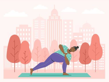 Şehir parkında açık havada yoga yapan bir adam. Erkek doğada döner açı pozu veriyor. Şehir parkındaki ağaçlı ve gökdelenli yoga minderinde spor egzersizleri. Sağlıklı yaşam tarzı kavramı.