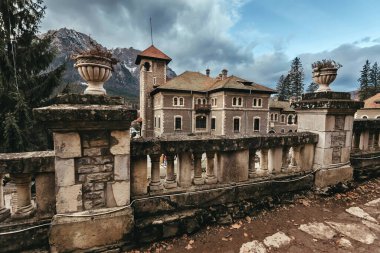 Cantacuzino castle in Busteni town in Bucegi Mountains. Cantacuzino palace from staircase with columns and stone vases, view in winter. Neo Romanian style monument and popular touristic attraction.