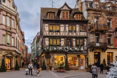 Colmar, Fransa - 3 Ocak 2020. Şenlikli Colmar Eski kasaba turist caddesi. Geleneksel Noel süslü evler Alsace 'de kış festivali boyunca.