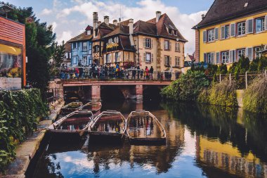Colmar, Fransa - 25 Aralık 2019. Colmar Eski kasaba ortaçağ dekore edilmiş evler, turist köprüsü ve Alsace 'de kış festivali sırasında Petite Venedik kanal bölgesinde tekneler.