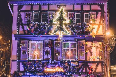 Colmar, Fransa - 25 Aralık 2019. Alsace 'de kış festivali sırasında geleneksel Colmar kenti Noel süsleri. Noel arifesine kadar eski şehirde dekore edilmiş Fransız evleri pencereleri ve şenlikli aydınlatma.