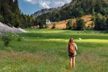Karadağ 'ın Durmitor Ulusal Parkı' ndaki yaz otlaklarında sırt çantalı bir kadın yürüyor. Susicko Gölü 'nün yeşil vadisinde yürüyüş yapan genç bekar kadın yaz boyunca tamamen kurumuş..