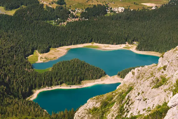 Kozalaklı ormanlarla çevrili Kara Göl 'ün havadan manzarası. Karadağ 'ın Durmitor ulusal parkındaki buzul gölü. Zabljak yakınlarındaki ünlü doğal manzara ve yürüyüş merkezi..