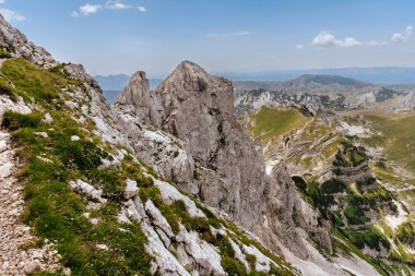 Durmitor Ulusal Parkı 'nda yaz dağı manzarası. Güneşli bir günde yüksek dağlı Dinarik Alpleri ve yeşil vadi manzarası. Balkan yürüyüşü macerası ve Karadağ 'ın popüler seyahat beldesi.