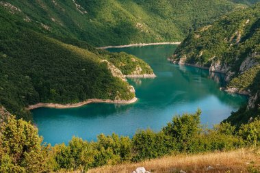Piva nehri kanyonundaki Piva Gölü, Karadağ 'ın kayaları ve dağları arasında yukarıdan görülüyor. Balkanlar 'da büyük bir yapay su deposu, Piva Doğa Parkının doğal simgesi..