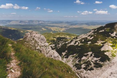 Durmitor Ulusal Parkı 'nda yaz dağı manzarası. Güneşli bir günde yüksek dağlarda doğa manzaralı yürüyüş yolu. Balkan yürüyüşü macerası ve Karadağ 'ın popüler seyahat beldesi.