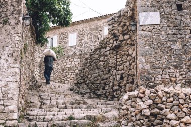 Himara 'nın eski kasabasında çanta taşıyan bir Arnavut. Ortaçağ şehrine kaldırım taşları sokakları ve eski geleneksel evlerle giriş. Arnavutluk 'un kültür mirası ve tarihi simgesi.