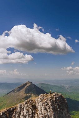 Suva Planina 'nın dağ yamacında duran bir adam. Kayalık dağlarda yalnız başına dağ manzarasında, erkek turistler yürüyüş yapıyor. Solo yürüyüş ve macera yolculuğu konsepti.