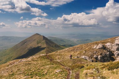 Gezgin kadın, Suva Planina dağlarında tek başına yürüyüş yapıyor. Sırbistan 'da popüler bir yürüyüş merkezi olan Trem Hiking yolunda tek başına yürüyen küçük bir kişi. Aktif yaşam tarzı, macera, tatil seyahati kavramı.