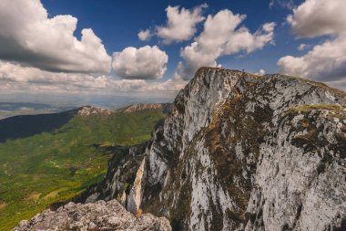 Trem 'in Suva Planina' nın en yüksek zirvesine, Carpatho-Balkan dağ kuşağına sahip dağ manzarası. Sırbistan 'da popüler bir yürüyüş noktası olan Kuru Dağ' ın kayalık uçurumunda duran minik kişi.