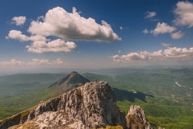 Suva Planina 'nın dağ yamacında duran bir adam. Kayalık dağlarda tek başına yürüyüş yapan erkek turist tepeden manzaranın tadını çıkarıyor. Solo yürüyüş ve macera yolculuğu konsepti.