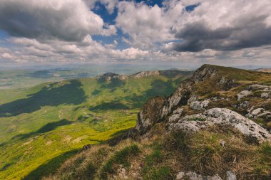 Suva Planina sıradağlarıyla manzara ve dramatik gökyüzünün altındaki yeşil vadi. Carpatho-Balkan dağ kuşağındaki Kuru Dağ 'dan Panorama. Sırbistan 'da popüler yürüyüş merkezinin manzarası.