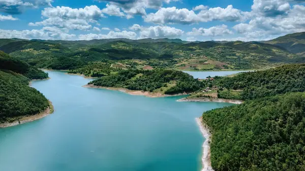 Rovni Gölü 'nün hava aracı görüntüsü yemyeşil ormanlar ve dağlarla çevrili. Güzel zümrüt göl manzarası, Sırbistan 'da popüler doğal cazibe dramatik bulutlar altında. Balkanlar 'ın doğasını keşfet.