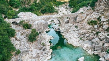 Arnavutluk 'taki Brataj Köprüsü' nün insansız hava aracı manzarası, Shushica Nehri üzerindeki taş köprü, tarihi mekan ve turistik yer. Seyahat kavramı ve Arnavut doğası ve kültüründe saklı mücevherleri keşfetme kavramı.