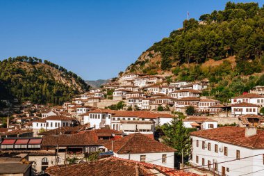 Arnavutluk 'un Berat kentindeki Mangalem bölgesinin manzarası, popüler turizm beldesi. Osmanlı döneminden kalma geleneksel taş evlerin manzarası ve yamaçlara kurulmuş tarihi muhitlerdeki kiremitli çatılar..