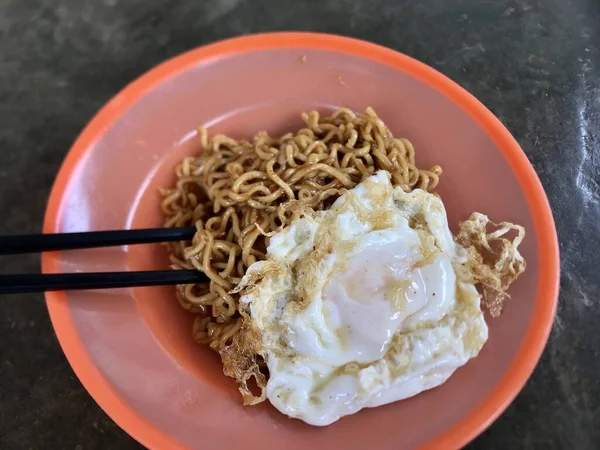 Close up of the noodles with sunny side up on plate with chopsticks 